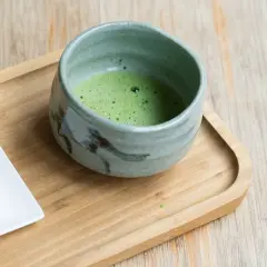 Zielone matcha w ceramicznej miseczce, obok małe bezy. Jak stosować keto matcha blue?