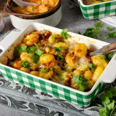 Zapiekane gnocchi z mięsem mielonym i serem, idealne jako gnocchi przepis z czym podawać. Posypane świeżą natką pietruszki.