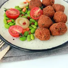 Talerz z kotletami sojowymi, pomidorkami, edamame i marchewką. Czy kotlety sojowe są zdrowe? Wyglądają apetycznie!