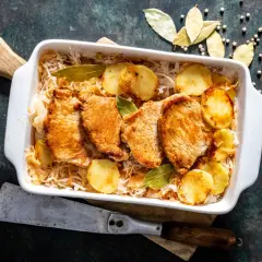 Aromaticzny schab w kapuście kiszonej z ziemniakami i liśćmi laurowymi, gotowy do podania.