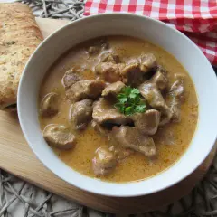 Aromaticzny, tradycyjny gulasz wieprzowy w kremowym sosie, udekorowany natką pietruszki, podany z chrupiącym pieczywem.
