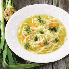 Aksamitny rosół z makaronem i marchewką, ozdobiony natką pietruszki. Idealny na lekki posiłek, niskokaloryczny rosół kcal.
