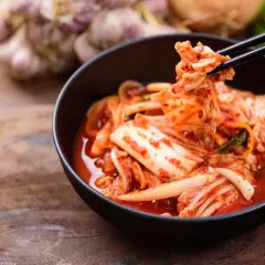 Kimchi jak smakuje? Pikantnie, kwaśno i orzeźwiająco. Kapusta pekińska w intensywnym sosie z chili i czosnkiem, podana pałeczkami.