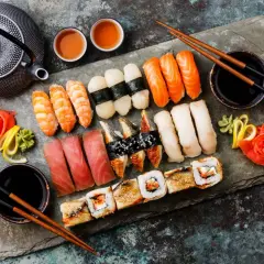 Zestaw sushi z krewetkami, łososiem, tuńczykiem i węgorzem, podany z imbirem, wasabi i sosem sojowym.