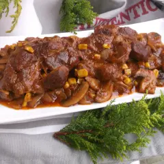 Karkówka pieczona w plastrach z cebulą i pieczarkami, polana sosem z dodatkiem kukurydzy. Pyszne danie, które zachwyci każdego.