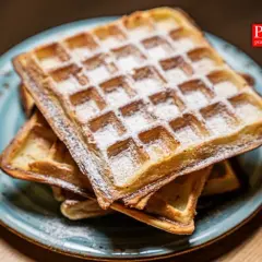 Stary przepis na gofry, lekko oprószone cukrem pudrem, kuszą na talerzu. Idealne na leniwe śniadanie.