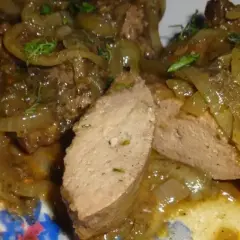Pyszna wątróbka w sosie z cebulką, podana z chlebem. Aromatyczne danie, które rozpływa się w ustach.
