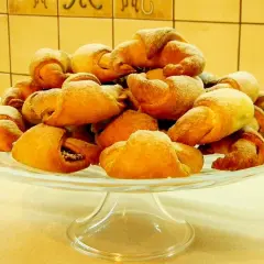 Rogaliki drożdżowe, pachnące jak u babci, na szklanej paterze. Idealne na deser, zgodnie z jej przepisem.