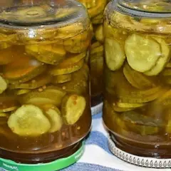 Słoiki pełne plastrów ogórków z curry, gotowe do spiżarni.