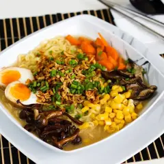 Apetyczny tantanmen z jajkiem na pół, kukurydzą, marchewką i grzybami.