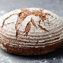 Chleb na zakwasie, pachnący jak u babci. Jego skórka posypana mąką i ziarnami zachęca do spróbowania tego tradycyjnego przepisu.