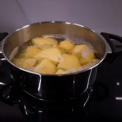 Gotowane ziemniaki w garnku, gotowe do przygotowania pysznej sałatki ziemniaczanej.