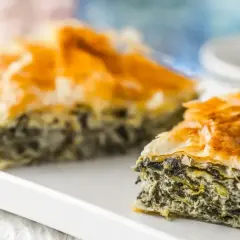 Chrupiąca spanakopita z warstwami ciasta filo i zielonym nadzieniem ze szpinaku i sera feta.