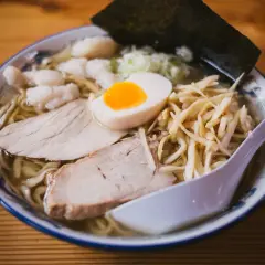 Miseczka ramenu z plastrami mięsa, jajkiem i bambusem. Czy można jeść ramen w ciąży? To danie wygląda apetycznie!