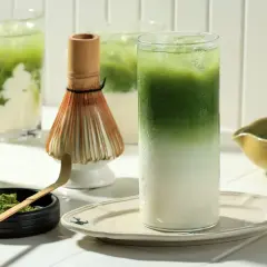 Zielony napój z lodem i mlekiem, proszek matcha, bambusowa miotełka. Czy matcha jest zdrowa? Tak, to napój pełen antyoksydantów.