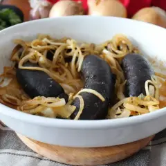 Pyszna kaszanka z piekarnika, zapieczona z cebulką w białej misie. Aromatyczne danie gotowe do podania.
