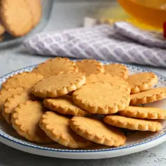 Stos szybkich kruchych ciasteczek na talerzu z niebieskim wzorem. Idealne na popołudniową herbatę.