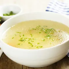 Aromaticzny rosół z perliczki, podany z chlebem i natką pietruszki. Idealny na chłodne dni.