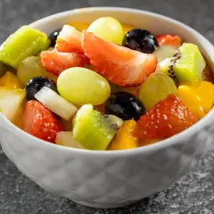 Kolorowa sałatka owocowa z truskawkami, kiwi, winogronami i mango. Idealna na deser, a czym polać sałatkę owocową? Może jogurtem lub syropem!