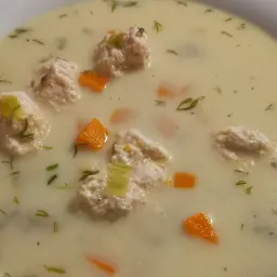 Kremowa zupa królewska z delikatnymi kluseczkami drobiowymi, marchewką i koperkiem. Pyszne danie na chłodne dni.