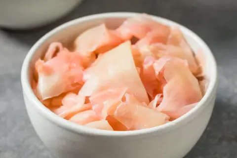 Różowy imbir marynowany w miseczce, gotowy do podania z sushi.