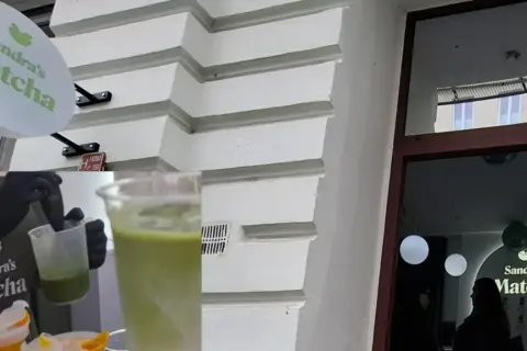 Znak "Sandra's Matcha", przygotowywanie napoju matcha, witryna sklepu.