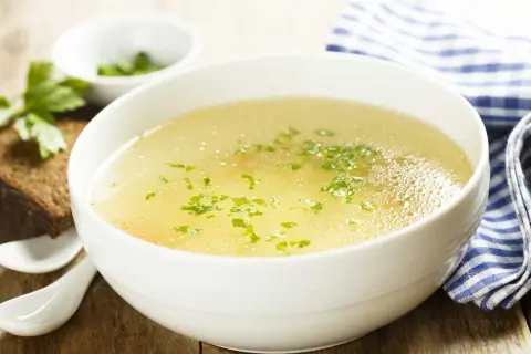 Aromaticzny rosół z perliczki, podany z chlebem i natką pietruszki. Idealny na chłodne dni.