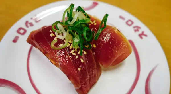 Dwa kawałki tuńczyka na ryżu, posypane sezamem i szczypiorkiem. Zastanawiasz się, ile kosztuje sushi w Japonii?
