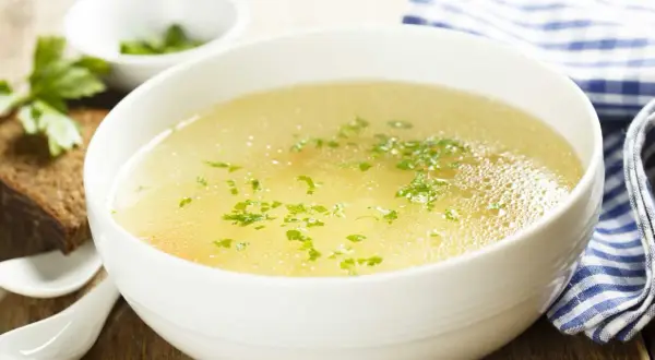 Aromaticzny rosół z perliczki, podany z chlebem i natką pietruszki. Idealny na chłodne dni.