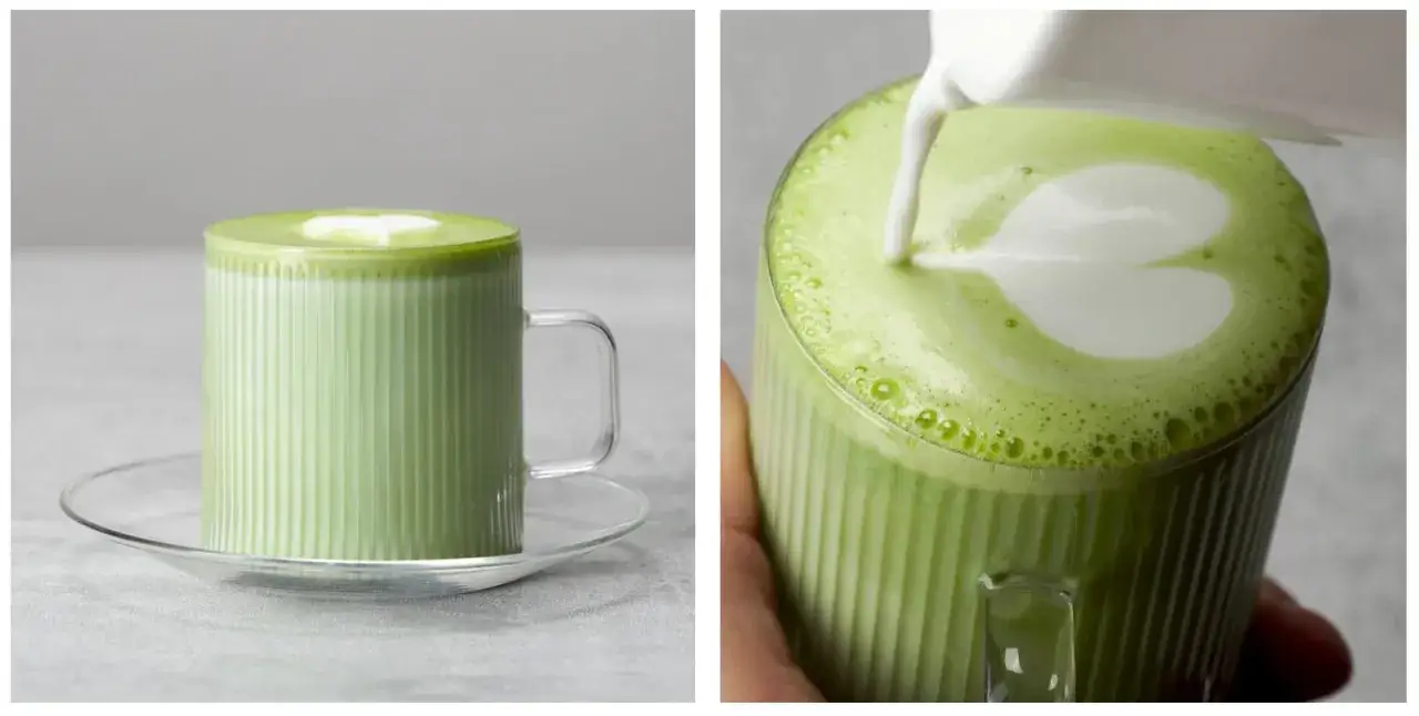 Jak pić matcha? Zielony napój w szklance z pianką w kształcie serca. Mleko wlewane do napoju tworzy artystyczny wzór.