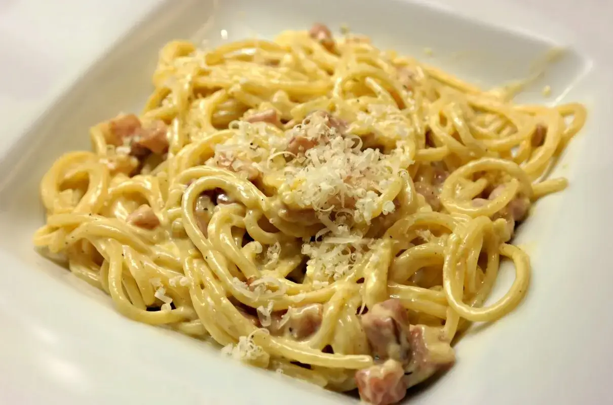 Spaghetti carbonara - przepis oryginalny ze śmietaną. Kremowy sos, kawałki guanciale i parmezan otulają złocisty makaron.