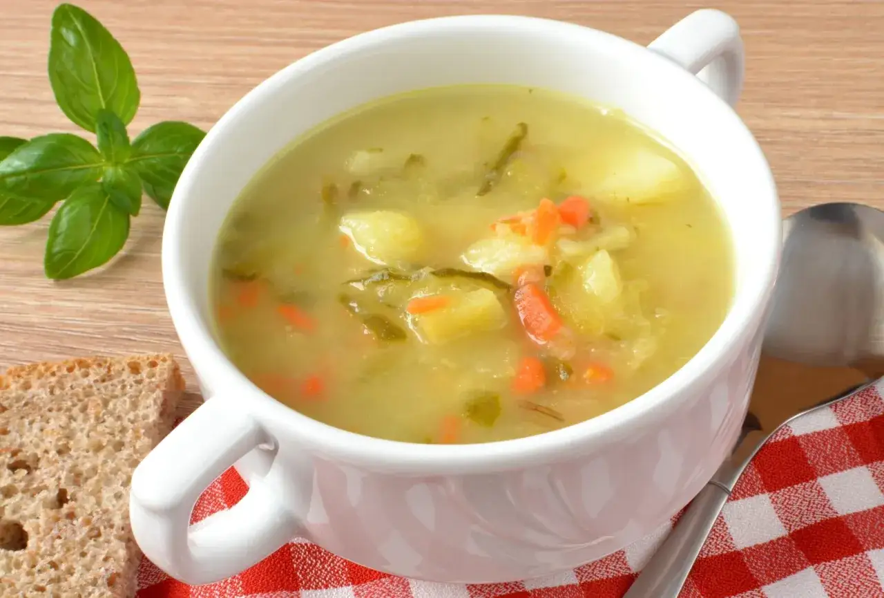 Aksamitna zupa ogórkowa przepis babci, pełna ziemniaków i marchewki, podana z chlebem i bazylią.