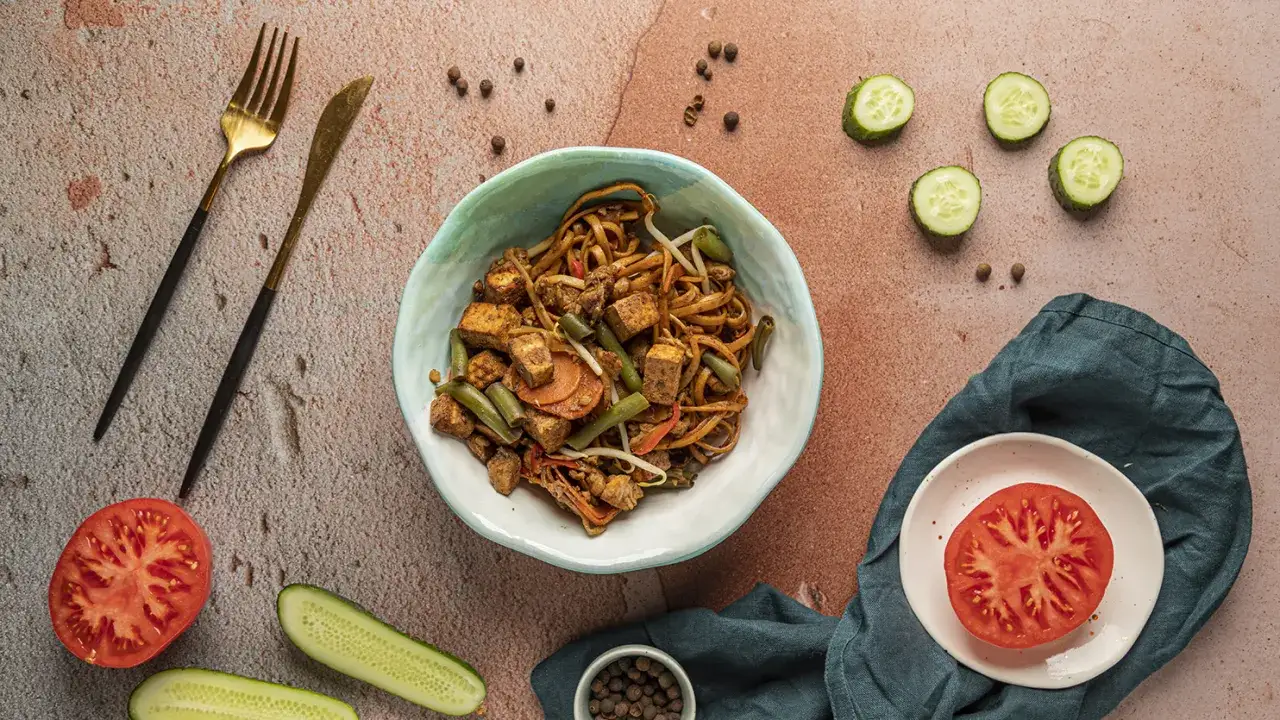 Makaron chow mein z tofu, fasolką szparagową i warzywami. Idealny do podania z pomidorem i ogórkiem.