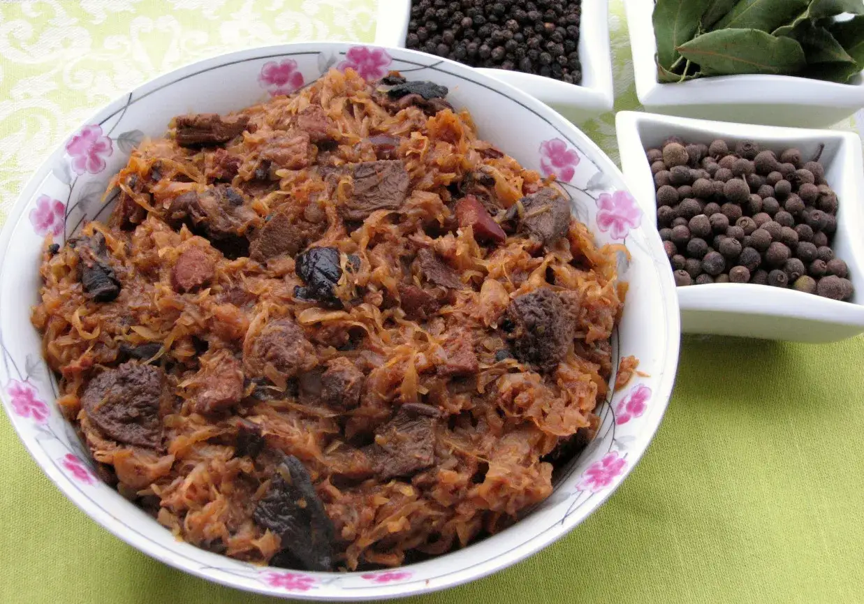 Tradycyjny polski bigos przepisy mistrzów. Aromatyczne danie z kapusty i mięsa, obok przyprawy.