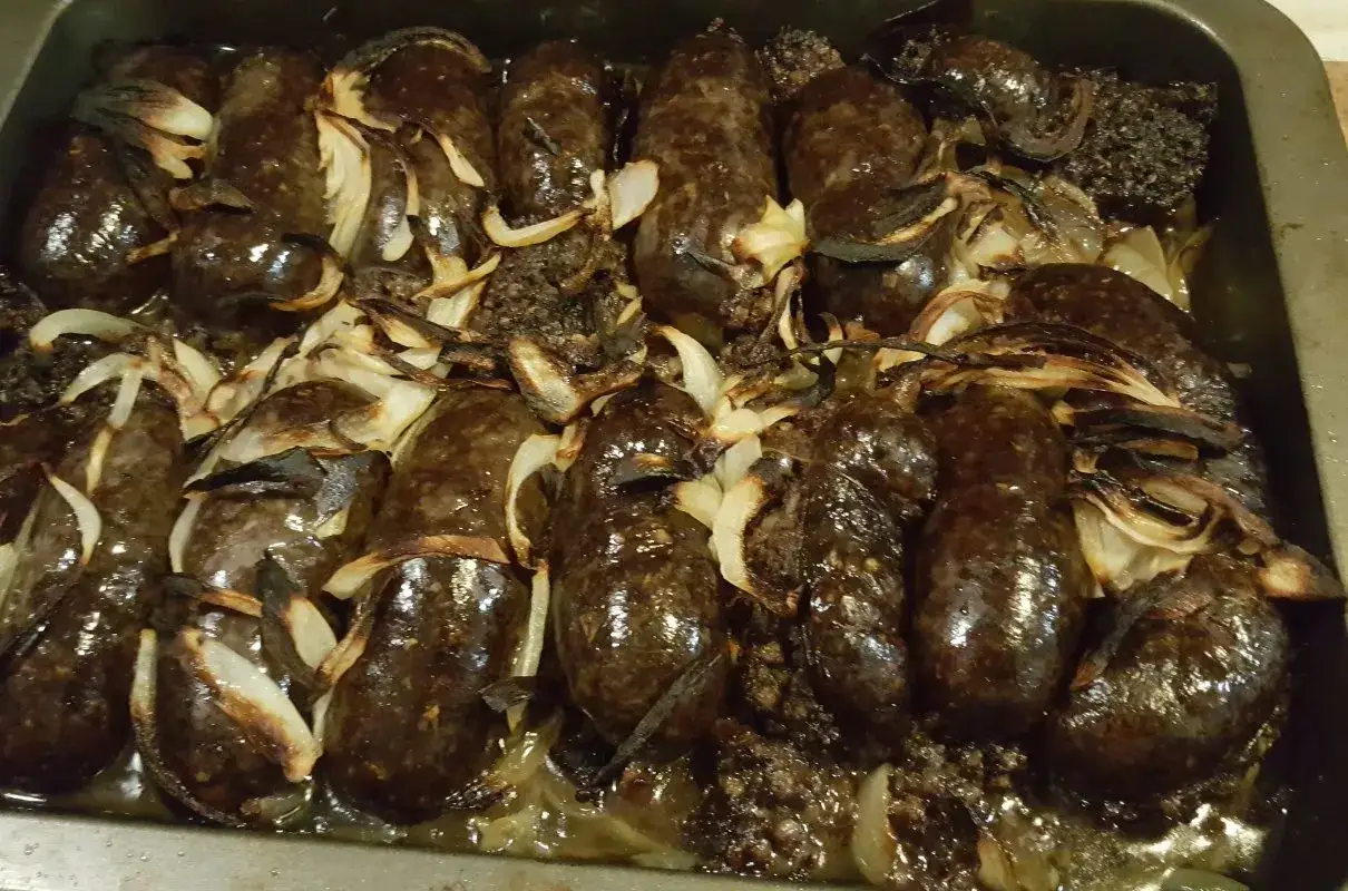 Pyszna kaszanka z piekarnika, pieczona z cebulką, aż nabrała apetycznego, lekko przypieczonego koloru.