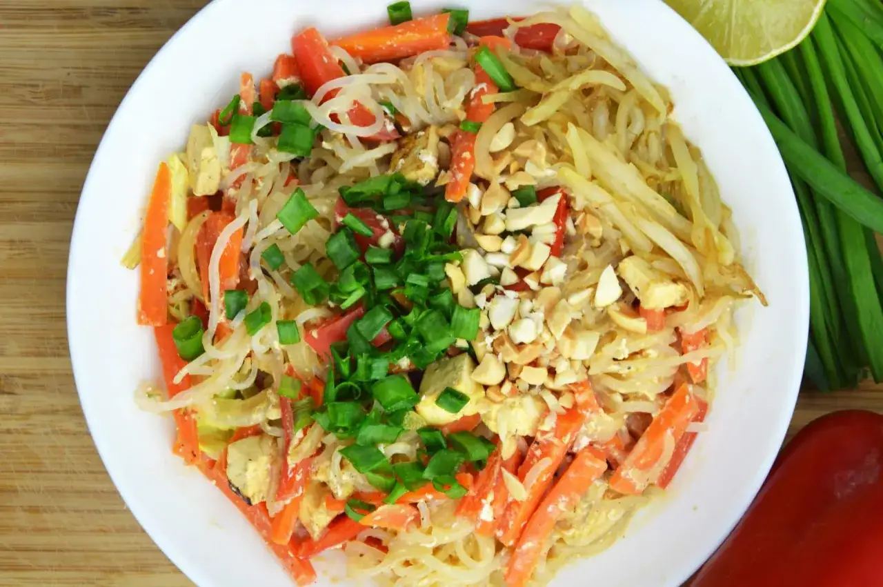 Talerz pełen Pad Thai z marchewką, tofu i orzeszkami ziemnymi. Zastanawiasz się, ile kalorii ma Pad Thai?