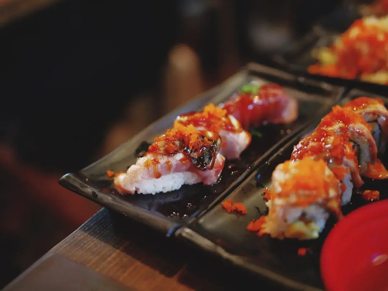 Pyszne sushi z łososiem i ikrą. Idealne do tego zielona herbata lub sake. Co pić do sushi? Wybór należy do Ciebie!