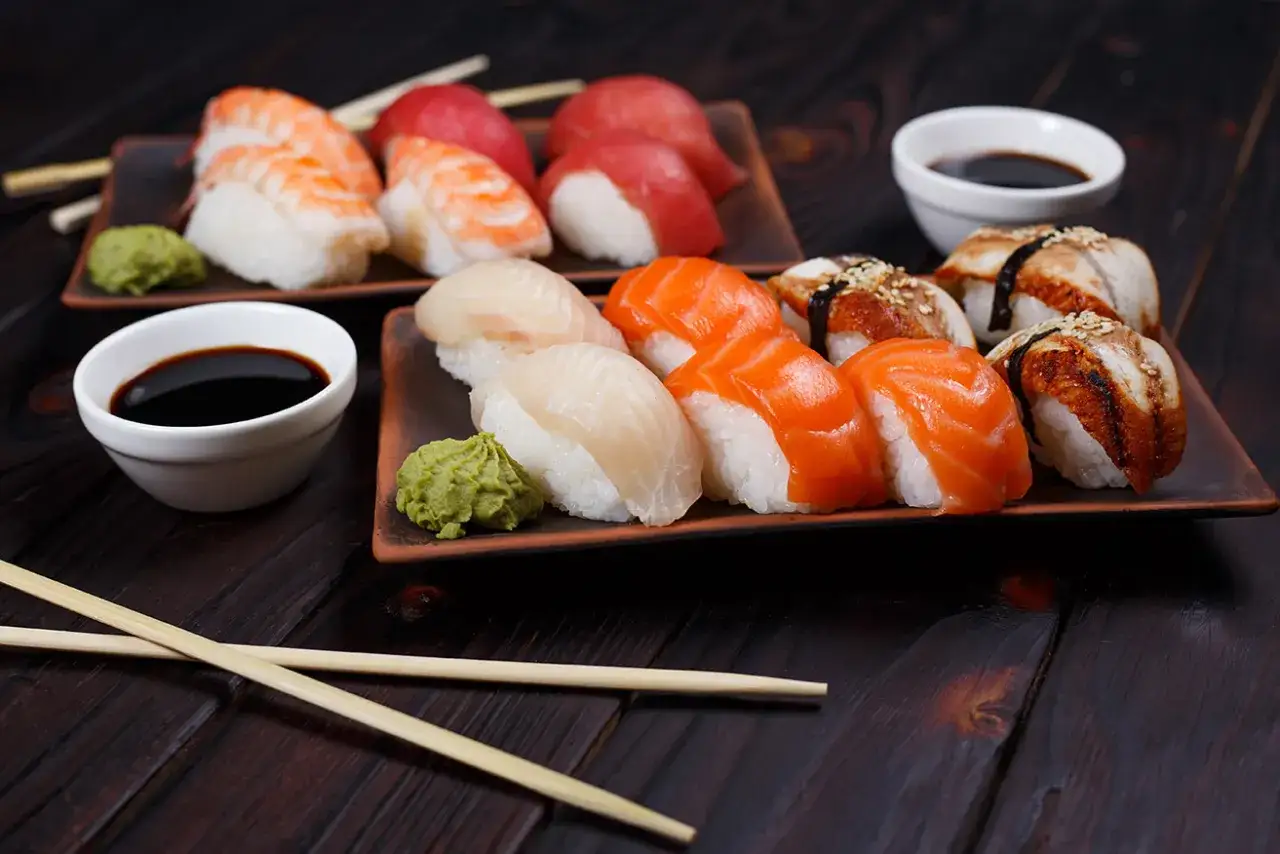 Różnorodne sushi: krewetkowe, łososiowe, z białej ryby i węgorza. To kwintesencja japońskiej kuchni, podane z wasabi i sosem sojowym.