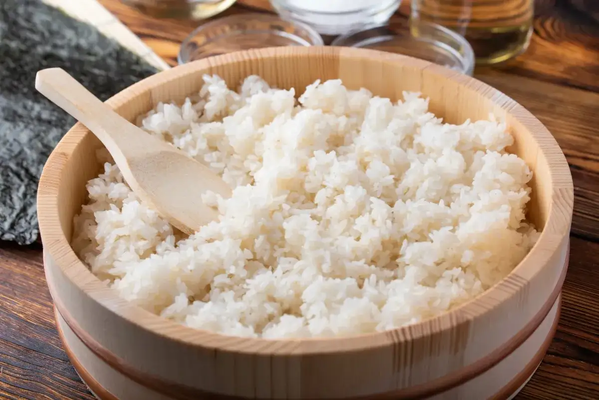 Idealny ryż do sushi w drewnianym naczyniu, gotowy do przygotowania pysznych rolek.