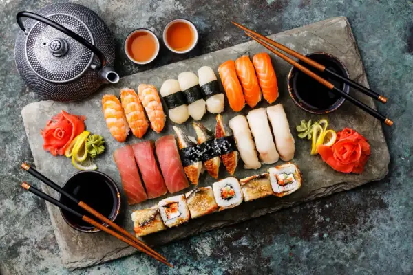 Zestaw sushi z krewetkami, łososiem, tuńczykiem i węgorzem, podany z imbirem, wasabi i sosem sojowym.