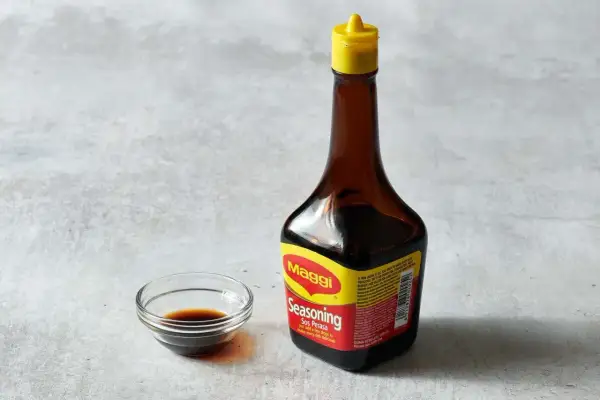 Butelka Maggi i miseczka z ciemnym płynem. Czy sos sojowy można zastąpić maggi?