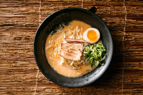 Miseczka aromatycznego ramenu z makaronem, chashu, jajkiem i szczypiorkiem. Idealny sposób, by poczuć, jak smakuje ramen.