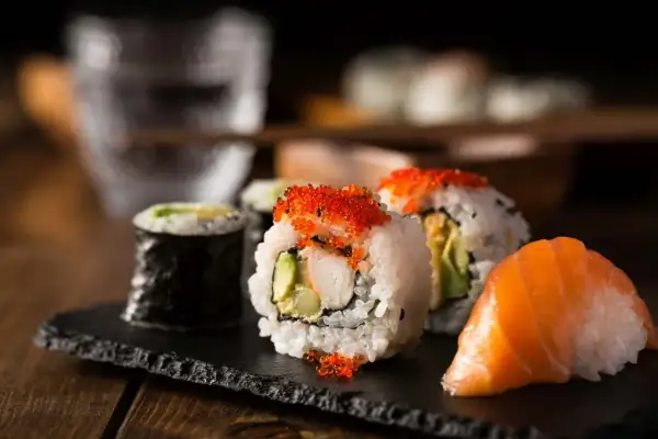 Pyszne sushi z łososiem, awokado i ikrą. Idealne składniki co do sushi do środka, by stworzyć wyśmienite danie.