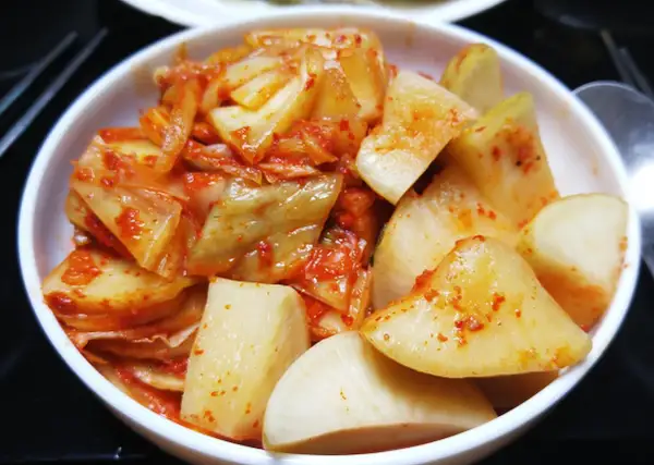 Pikantne kimchi w białej misce. Zastanawiasz się, jak długo przechowywać kimchi? To danie jest gotowe do spożycia!