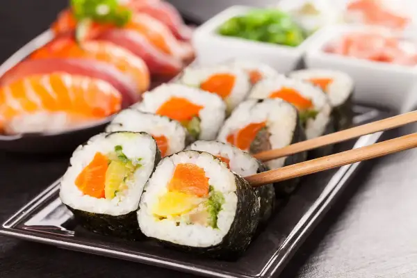 Pyszne rolki sushi z łososiem i warzywami, idealne na każdy posiłek. Do sushi najlepiej użyć specjalnego ryżu, który jest kleisty i lekko słodki.