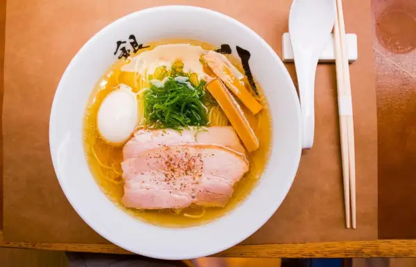 Misternie przygotowane ramen z plastrami wieprzowiny, jajkiem i szczypiorkiem. Zastanawiasz się, ile kalorii ma ramen?
