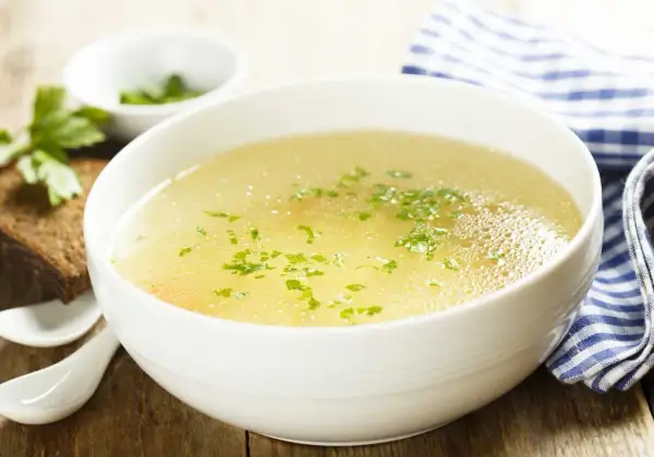 Aromaticzny rosół z perliczki, podany z chlebem i natką pietruszki. Idealny na chłodne dni.